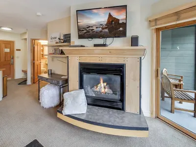 Gas fireplace with wall-mounted TV and balcony access